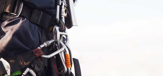 Equipment of industrial mountaineering worker on roof of building during industrial high-rise work. Climbing equipments before starting job. Rope laborer access. Concept of urban works. Copy space