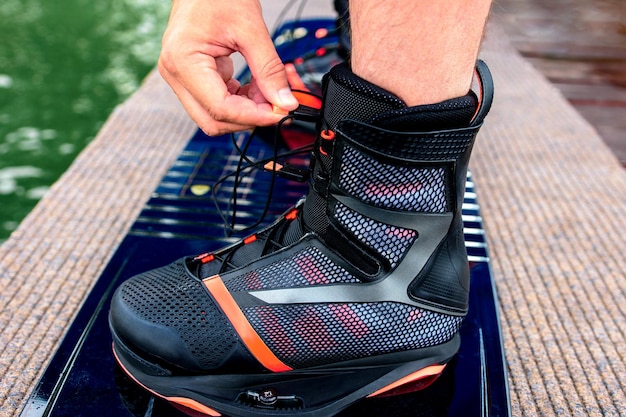 Equipment for wakeboarding. Man wears wake shoes