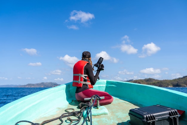 ボートで写真を話しながら働く装備の海洋生物学者