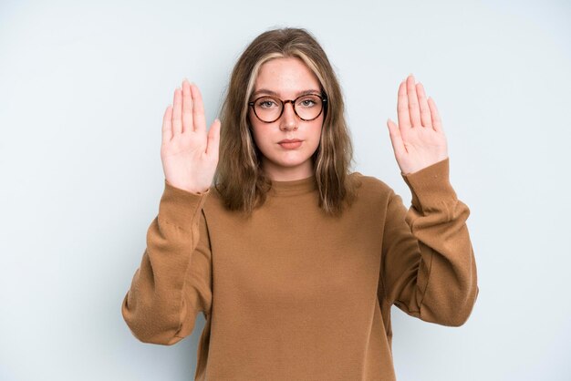 Er ernstig ongelukkig, boos en ontevreden uitzien, de toegang verbieden of stop zeggen met beide open handpalmen