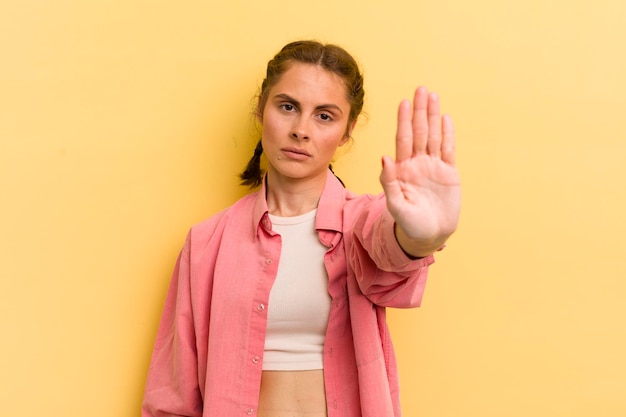 Er ernstig streng ontstemd en boos uitzien met een open handpalm die een stopgebaar maakt