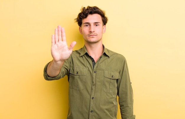 Er ernstig streng ontstemd en boos uitzien met een open handpalm die een stopgebaar maakt