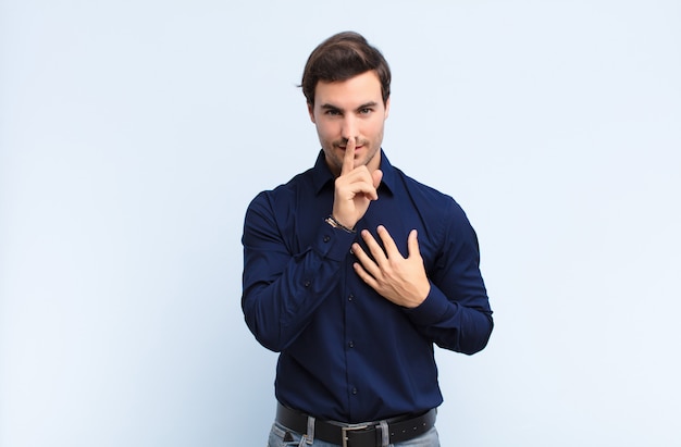 er ernstig uitziet en er met de vinger tegen de lippen tegen gedrukt, eist stilte of stilte en houdt een geheim