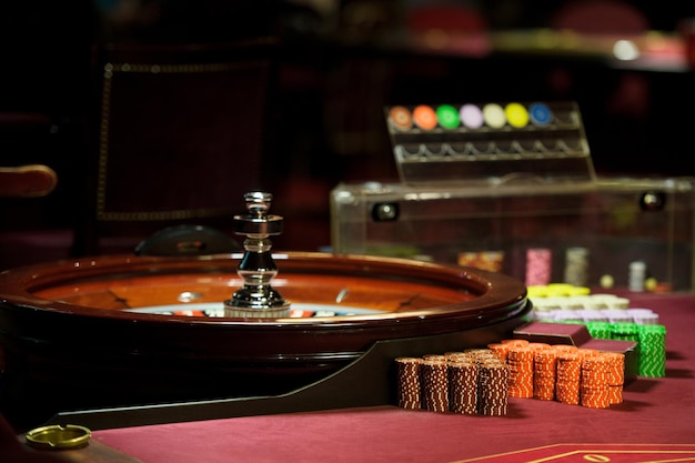 Er is een rode tafel met roulettefiches in het casino