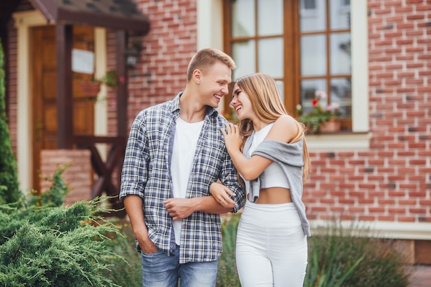 Er is liefde in de lucht. Gelukkig jong en paar die in openlucht koesteren lachen. Mooie familie vlakbij het huis.