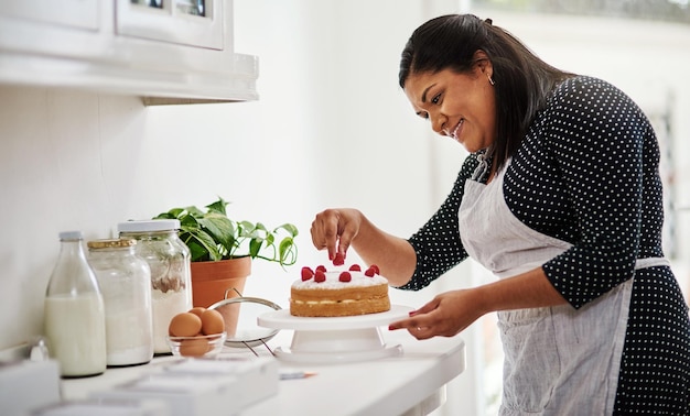 Er is niets waar ik meer van hou dan bakken Bijgesneden opname van een vrouw die een taart decoreert in haar keuken