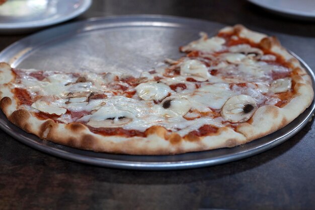 Er ligt pizza in het bord op tafel Gesneden pizza Rust in een café