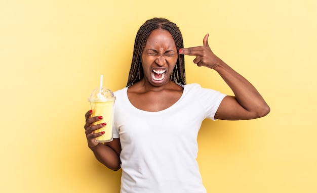 Er ongelukkig en gestrest uitzien, zelfmoordgebaar makend pistoolteken met de hand, wijzend naar het hoofd. milkshake concept