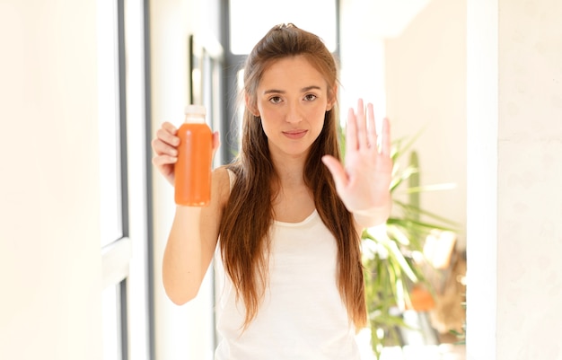 er serieus, streng, ontevreden en boos uitzien met een open handpalm die een stopgebaar maakt