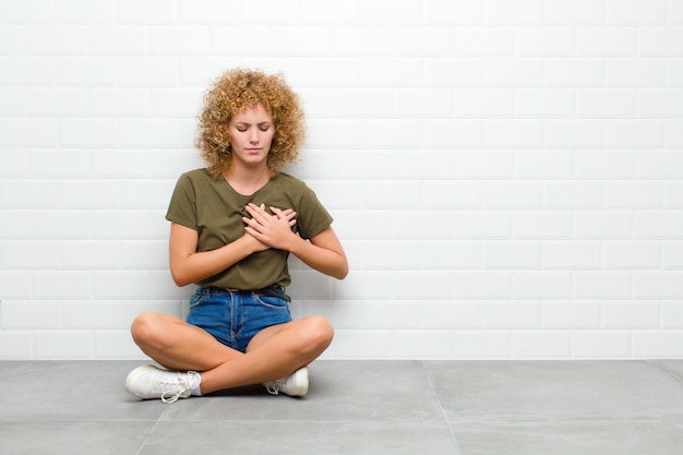 er verdrietig, gekwetst en verdrietig uitzien, beide handen dicht bij het hart houden, huilen en zich depressief voelen