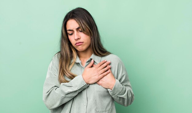 Er verdrietig uitzien, gekwetst en diepbedroefd, beide handen dicht bij het hart houdend, huilend en depressief voelend