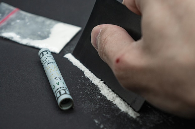Er wordt cocaïne gesnoven met links een dollarbiljet. Cocaïne drugsverslaving.