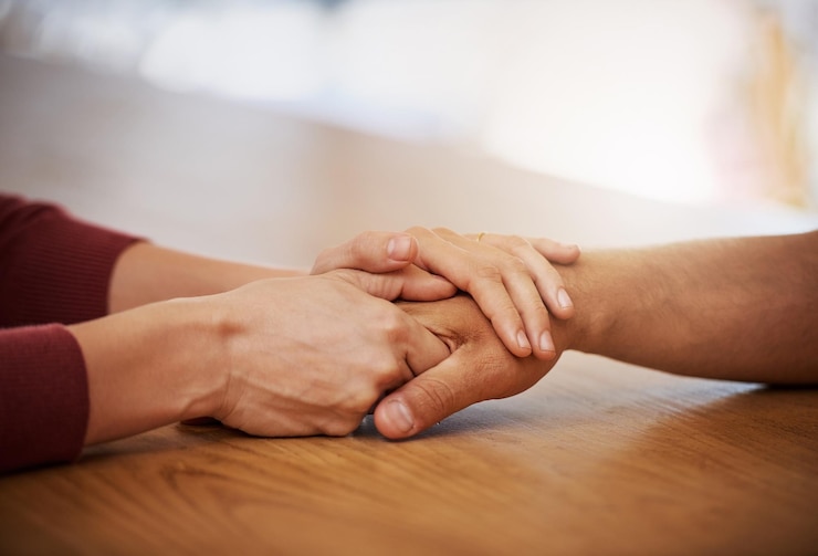 Foto er zal altijd hulp zijn bijgesneden opname van een niet-identificeerbare jonge vrouw die de hand van haar vrienden vasthoudt in een coffeeshop