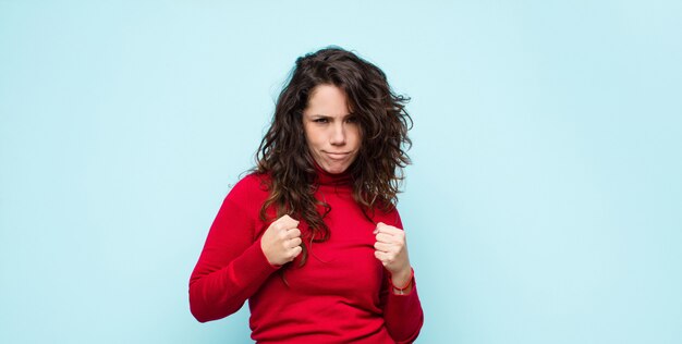 er zelfverzekerd, boos, sterk en agressief uitzien, met vuisten klaar om te vechten in bokspositie