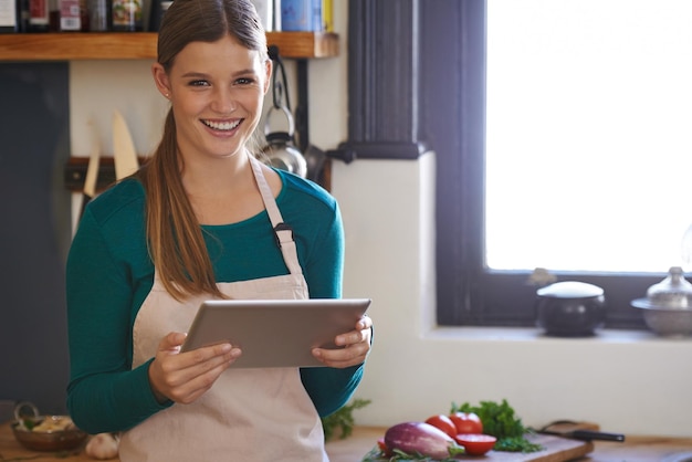 Er zijn zoveel recepten om uit te kiezen Portret van een jonge vrouw die online recepten zoekt op haar digitale tablet