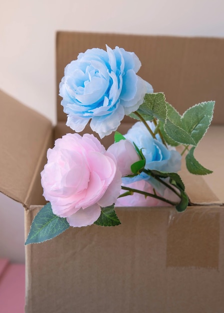 Er zitten twee bloemen in een bruine kartonnen doos roze en blauwe milieuvriendelijke verpakking