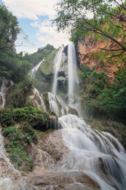 Erawan waterfall 7th floor with water flowing through natural stone in tropical rainforest at national park, Kanchanaburi, Thailand