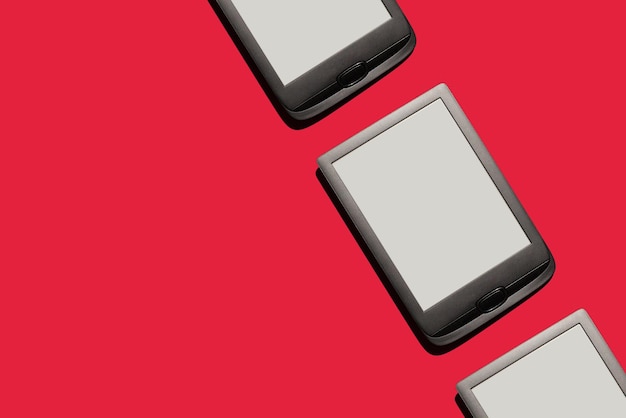 Фото Экраны планшетов для чтения электронных книг на красном фоне