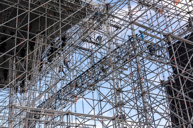 Photo erecting a stage for a concert. installers on the scaffolding