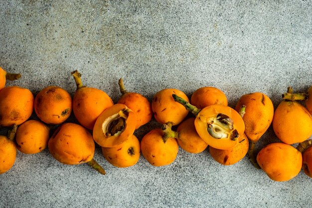 Фото eriobotrya japonica или плоды локвата, подаваемые на бетонном столе