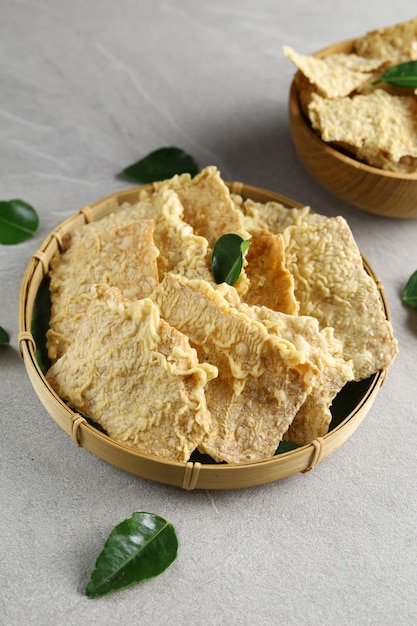 eripik tempe or tempeh chips on wooden plate Slices of tempeh coated with flour and fried crispy