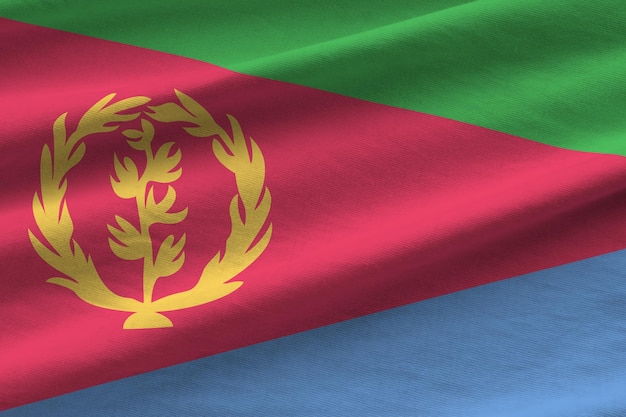 Eritrea flag with big folds waving close up under the studio light indoors The official symbols and colors in banner