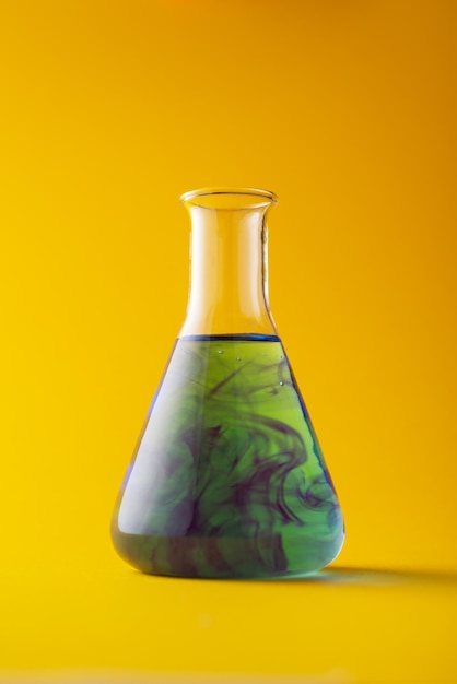 Erlenmeyer flask over yellow background