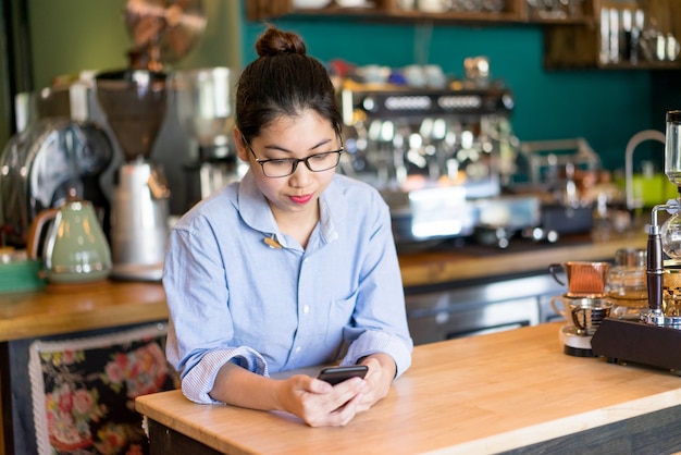 Ernstig de lezingsbericht van de koffiewinkel eigenaar op telefoon terwijl het wachten op cliënten