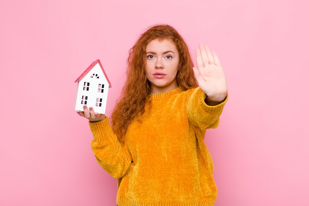 ernstig, streng, ontstemd en boos kijkend met open hand die een stopgebaar maakt