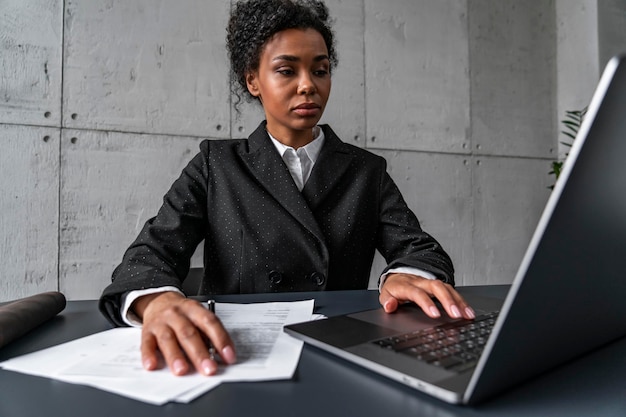 Ernstige Afrikaanse vrouw die met laptop werkt