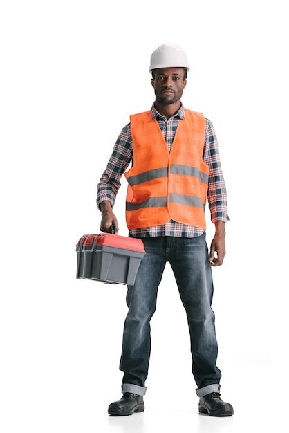 Ernstige Afro-Amerikaanse bouwvakker met toolbox geïsoleerd op wit