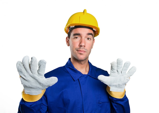 Ernstige arbeider met kalm gebaar op een witte achtergrond