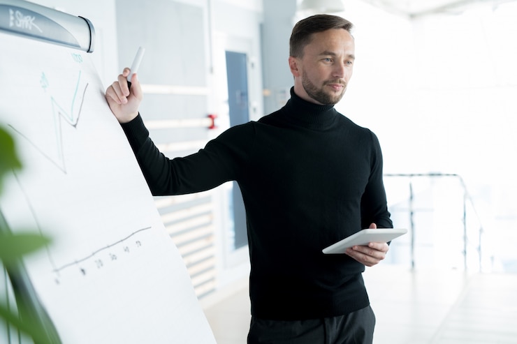 Foto ernstige business trainer grafiek uit te leggen