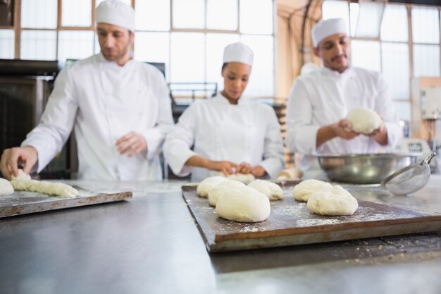 Ernstige collega&#39;s die ongekookt deeg kneden