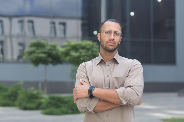 Ernstige en peinzende jonge kantoormedewerker met gekruiste armen kijkend naar camera zakenman in shirt