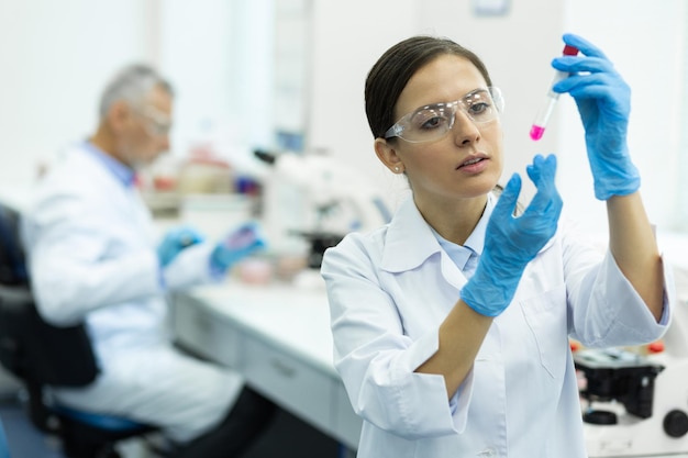 Ernstige jonge wetenschapper die chemisch experiment doet in het laboratorium