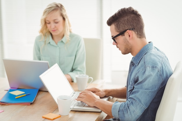 Ernstige man en vrouw die aan laptop werken