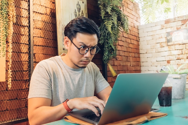 Ernstige man werkt op zijn laptop in het café.