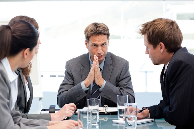 Ernstige manager die aan zijn team tijdens een vergadering spreekt