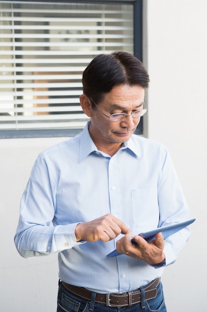 Ernstige mens die tablet in zijn tuin gebruikt