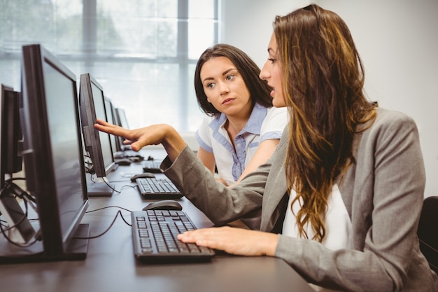 Ernstige onderneemsters die het computerscherm samen bekijken