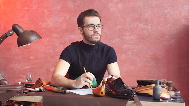 Ernstige schoenmaker, bezig met het maken van schoenen