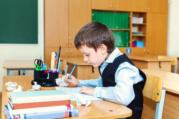 Ernstige schooljongen in de klas. Basisschool leerling. Terug naar school.