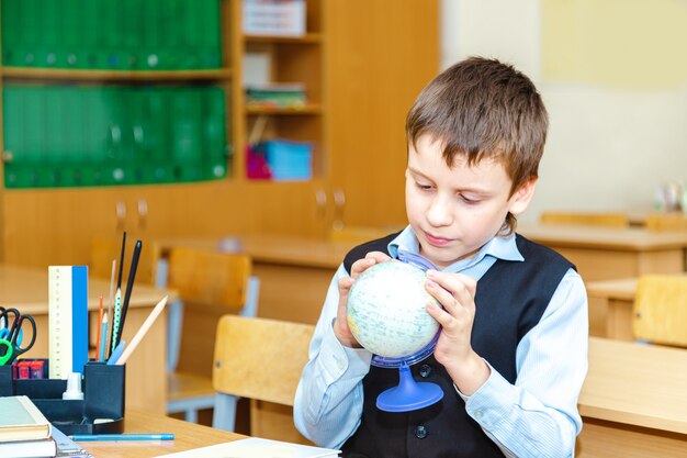 Ernstige schooljongen in de klas. Basisschool leerling. Terug naar school.