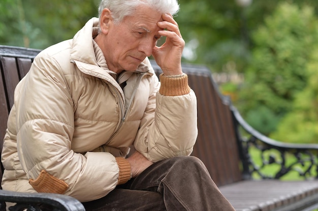 Ernstige senior man denken in park