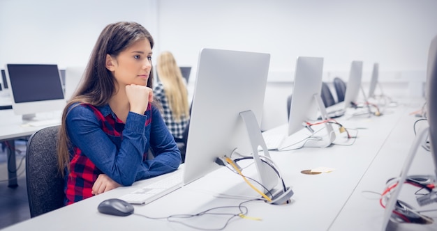 Ernstige student die aan computer bij universiteit werkt