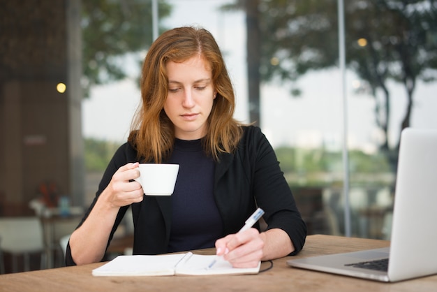 Ernstige Student met Koffiekop het Schrijven Nota&#39;s