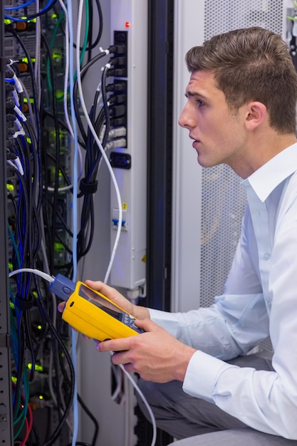 Ernstige technicus die digitale kabelanalysator op server gebruikt