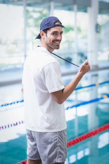 Ernstige trainer die chronometer bij de pool bekijkt