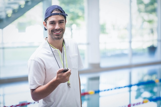 Ernstige trainer die chronometer bij de pool bekijkt